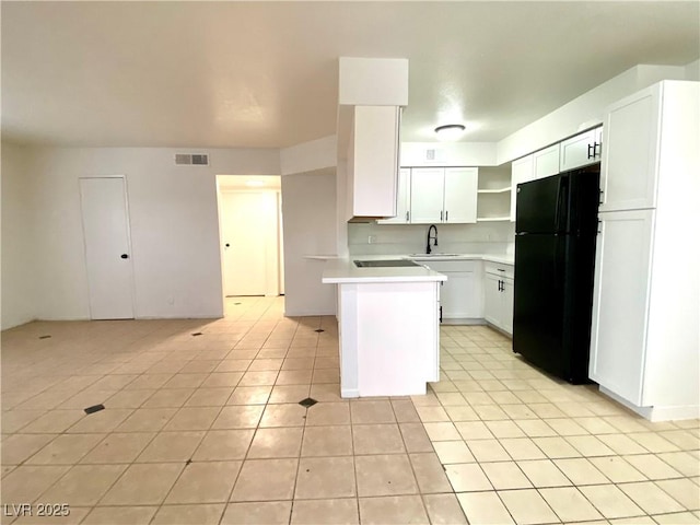 4980 Apollostar Ct, Las Vegas, NV 89115 - kitchen featuring freestanding refrigerator, light tile patterned flooring, a peninsula, light countertops, and open shelves