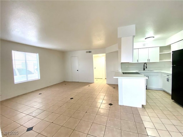 4980 Apollostar Ct, Las Vegas, NV 89115 - kitchen featuring freestanding refrigerator, light tile patterned floors, open floor plan, a peninsula, and light countertops