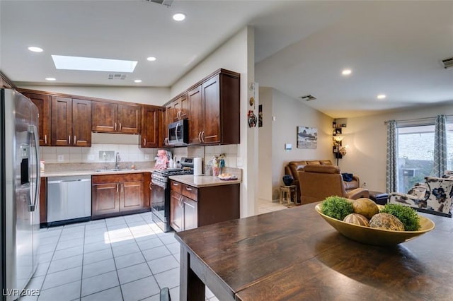 1949 King Hill St, Las Vegas, NV 89106 - kitchen featuring appliances with stainless steel finishes, a skylight, tasteful backsplash, light tile patterned floors, and recessed lighting