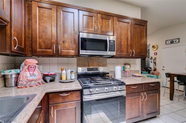 1949 King Hill St, Las Vegas, NV 89106 - kitchen featuring appliances with stainless steel finishes, backsplash, and light tile patterned flooring