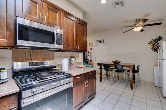 1949 King Hill St, Las Vegas, NV 89106 - kitchen with appliances with stainless steel finishes, ceiling fan, light countertops, decorative backsplash, and light tile patterned flooring