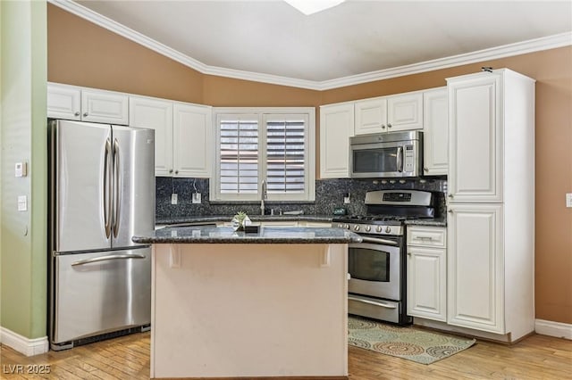 5580 Lonesome Biker Ln, Las Vegas, NV 89113 - kitchen with stainless steel appliances, a kitchen island, light wood-style floors, tasteful backsplash, and crown molding