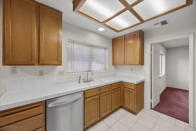 2344 Valleywood St, Henderson, NV 89014 - kitchen with dishwasher, light tile patterned floors, brown cabinets, and light countertops