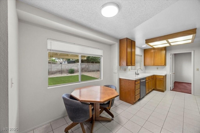2344 Valleywood St, Henderson, NV 89014 - kitchen with dishwasher, light countertops, light tile patterned flooring, a textured ceiling, and brown cabinetry
