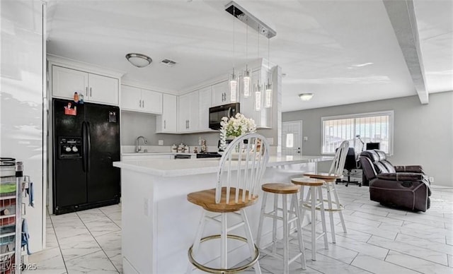824 Salem Dr, Las Vegas, NV 89107 - kitchen with black appliances, light marble finish floors, light countertops, a kitchen breakfast bar, and open floor plan