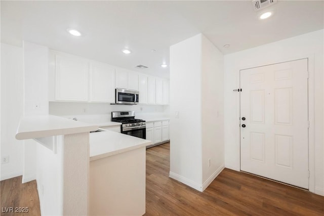1161 Gecko Rd, Henderson, NV 89002 - kitchen featuring stainless steel appliances, wood finished floors, white cabinets, light countertops, and recessed lighting