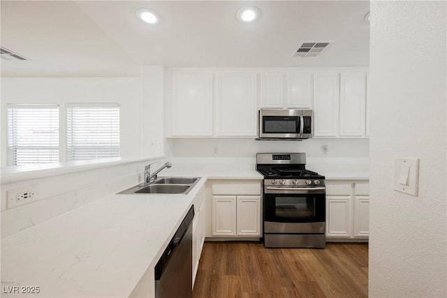 1161 Gecko Rd, Henderson, NV 89002 - kitchen with stainless steel appliances, dark wood finished floors, white cabinets, light countertops, and recessed lighting