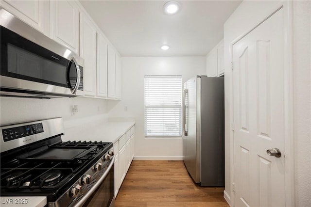 1161 Gecko Rd, Henderson, NV 89002 - kitchen featuring stainless steel appliances, white cabinets, light wood-style floors, light countertops, and recessed lighting