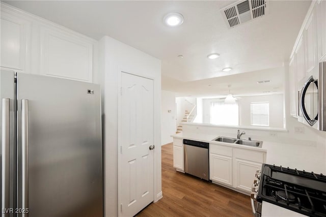 1161 Gecko Rd, Henderson, NV 89002 - kitchen featuring stainless steel appliances, white cabinetry, wood finished floors, light countertops, and recessed lighting