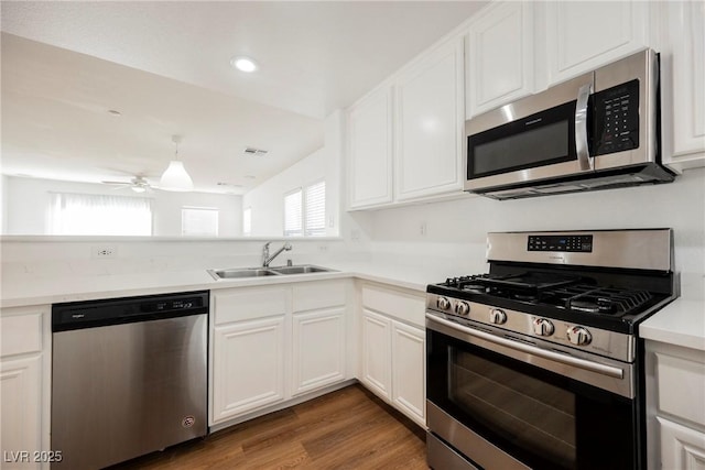 1161 Gecko Rd, Henderson, NV 89002 - kitchen featuring appliances with stainless steel finishes, a ceiling fan, white cabinets, light countertops, and wood finished floors