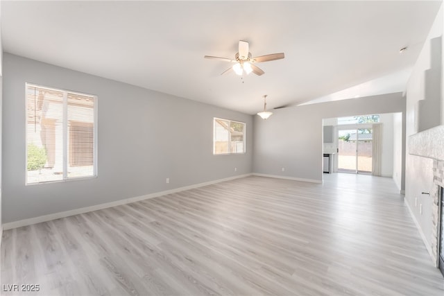 5524 Cleary Ct, Las Vegas, NV 89108 - empty room with ceiling fan, vaulted ceiling, a tile fireplace, and light wood-style flooring