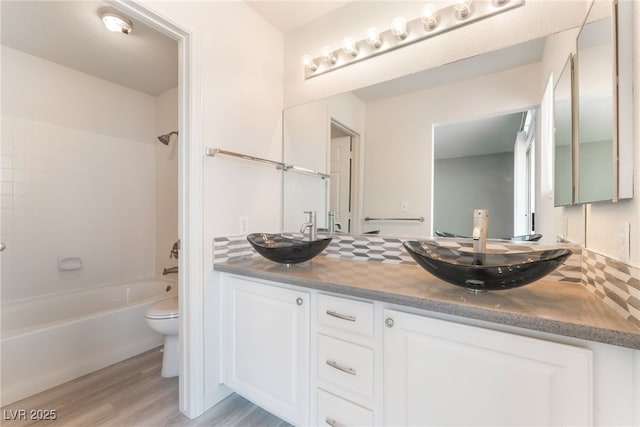 5524 Cleary Ct, Las Vegas, NV 89108 - bathroom with double vanity, wood finished floors, tub / shower combination, and backsplash