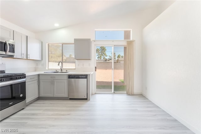 5524 Cleary Ct, Las Vegas, NV 89108 - kitchen with stainless steel appliances, gray cabinets, lofted ceiling, light wood-style flooring, and recessed lighting