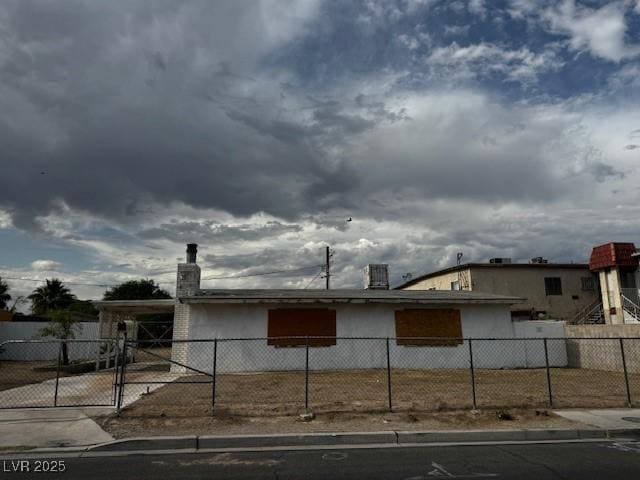 2645 Cedar Ave, Las Vegas, NV 89101 - view of front facade with an attached carport, a fenced front yard, stucco siding, a chimney, and concrete driveway