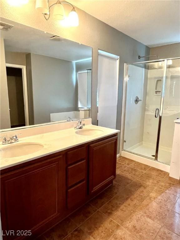 10450 Badger Ravine St, Las Vegas, NV 89178 - full bath with a shower stall, double vanity, a textured ceiling, and tile patterned flooring