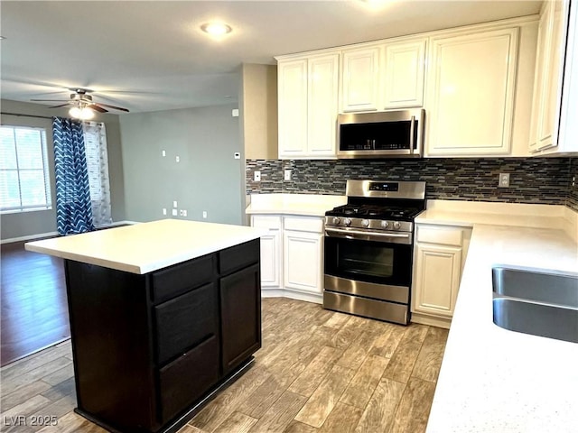 10450 Badger Ravine St, Las Vegas, NV 89178 - kitchen with appliances with stainless steel finishes, light wood finished floors, light countertops, and decorative backsplash