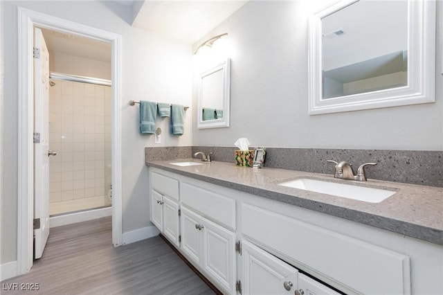 9836 Russett Wood Cir, Las Vegas, NV 89117 - full bathroom with double vanity, tiled shower, and wood finished floors