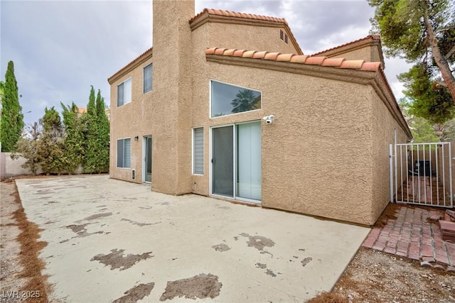 9836 Russett Wood Cir, Las Vegas, NV 89117 - rear view of property featuring stucco siding, a patio, and a chimney