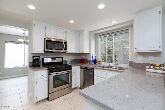 9836 Russett Wood Cir, Las Vegas, NV 89117 - kitchen featuring stainless steel appliances, light stone counters, a chandelier, white cabinetry, and recessed lighting