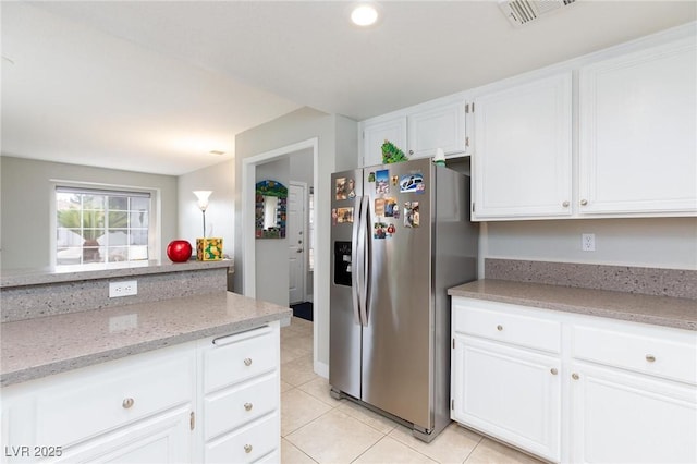 9836 Russett Wood Cir, Las Vegas, NV 89117 - kitchen with stainless steel fridge with ice dispenser, light tile patterned floors, white cabinets, light stone counters, and recessed lighting
