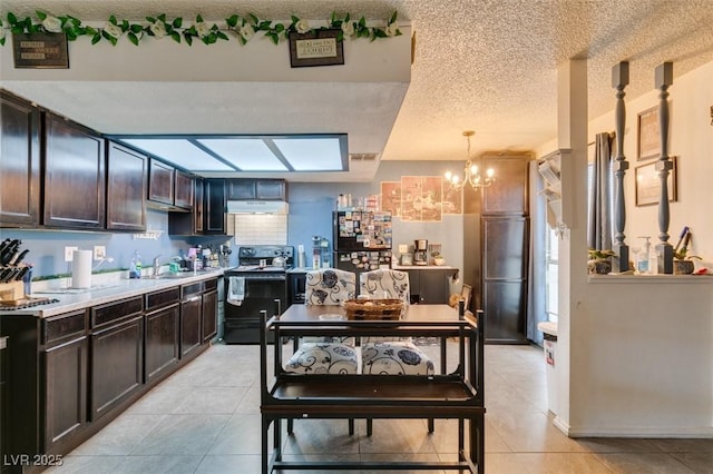 4300 N Lamont St Unit 275, Las Vegas, NV 89115 - kitchen featuring electric range, under cabinet range hood, freestanding refrigerator, a chandelier, and dark brown cabinetry