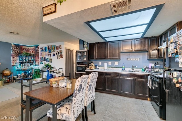 4300 N Lamont St Unit 275, Las Vegas, NV 89115 - kitchen with black appliances, dark brown cabinetry, light countertops, a textured ceiling, and light tile patterned floors