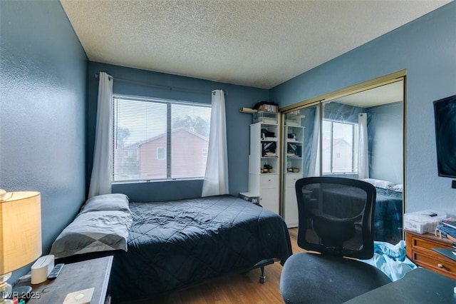 4300 N Lamont St Unit 275, Las Vegas, NV 89115 - bedroom with wood finished floors, a textured ceiling, multiple windows, and a closet
