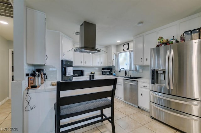 1705 Ivanhoe Way, Las Vegas, NV 89102 - kitchen with black appliances, island range hood, light tile patterned floors, tasteful backsplash, and recessed lighting