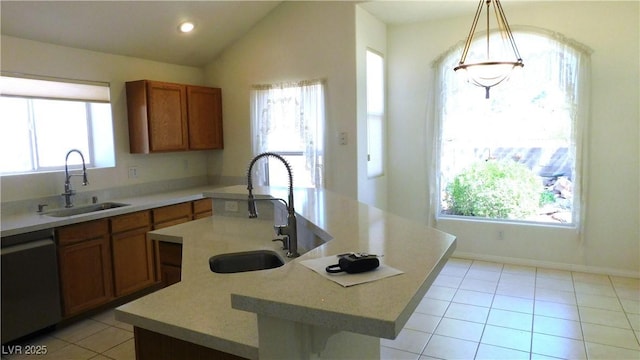 2587 Mizzoni Cir, Henderson, NV 89052 - kitchen featuring stainless steel dishwasher, light countertops, light tile patterned flooring, brown cabinets, and vaulted ceiling
