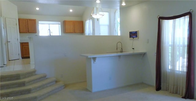2587 Mizzoni Cir, Henderson, NV 89052 - kitchen with brown cabinets, light countertops, recessed lighting, light carpet, and a peninsula
