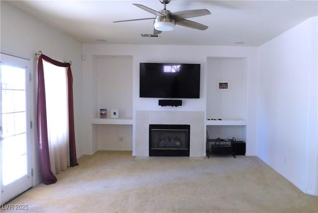 2587 Mizzoni Cir, Henderson, NV 89052 - unfurnished living room featuring carpet floors, ceiling fan, and a tiled fireplace