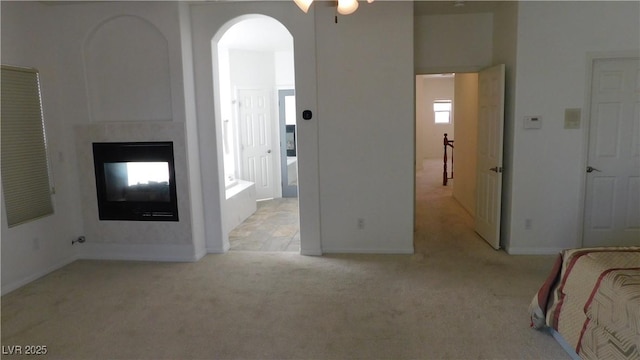 2587 Mizzoni Cir, Henderson, NV 89052 - unfurnished bedroom with light carpet, a multi sided fireplace, and arched walkways