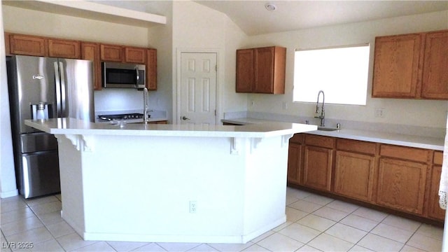 2587 Mizzoni Cir, Henderson, NV 89052 - kitchen with appliances with stainless steel finishes, brown cabinets, and vaulted ceiling