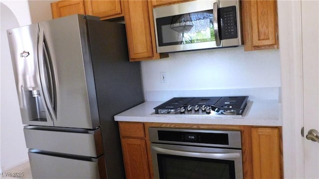 2587 Mizzoni Cir, Henderson, NV 89052 - kitchen featuring appliances with stainless steel finishes, light countertops, and brown cabinetry