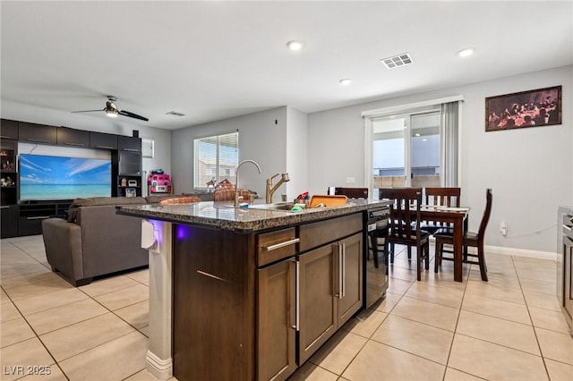 5246 Belmont Mill Ct, Las Vegas, NV 89122 - kitchen with light tile patterned floors, dark stone counters, dishwasher, a ceiling fan, and open floor plan