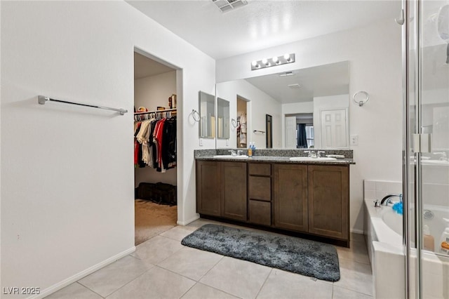 5246 Belmont Mill Ct, Las Vegas, NV 89122 - bathroom featuring double vanity, a garden tub, a shower stall, and tile patterned floors