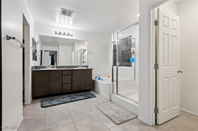 5246 Belmont Mill Ct, Las Vegas, NV 89122 - bathroom featuring a garden tub, a shower stall, double vanity, and tile patterned floors