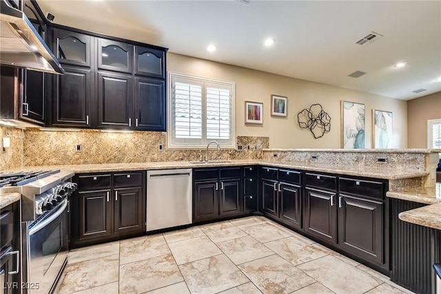 5681 Exotic Rosette Ave, Las Vegas, NV 89139 - kitchen featuring appliances with stainless steel finishes, ventilation hood, light stone counters, recessed lighting, and tasteful backsplash