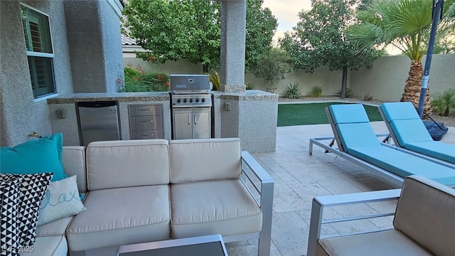 5681 Exotic Rosette Ave, Las Vegas, NV 89139 - fenced backyard with an outdoor living space, an outdoor kitchen, and a patio area