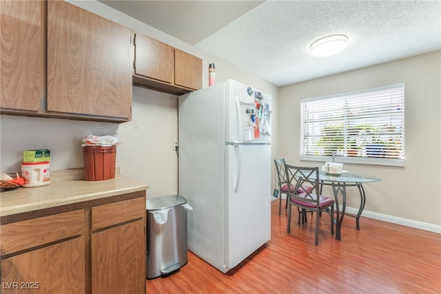 2666 Aarondavid Dr, Las Vegas, NV 89121 - kitchen featuring freestanding refrigerator, light wood finished floors, light countertops, and a textured ceiling