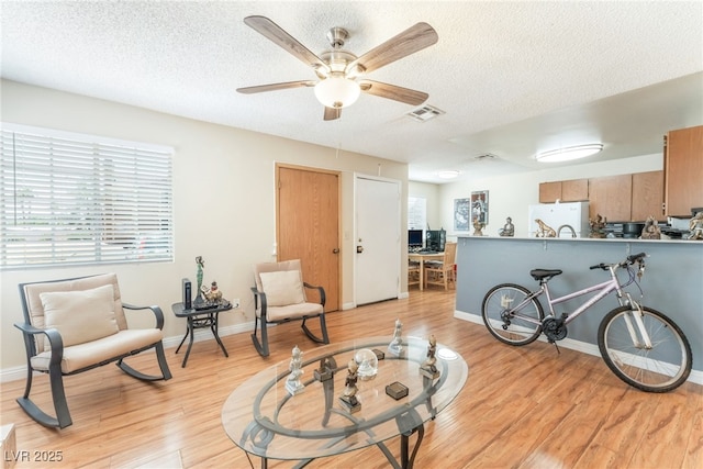 2666 Aarondavid Dr, Las Vegas, NV 89121 - living area with light wood finished floors, healthy amount of natural light, ceiling fan, and a textured ceiling