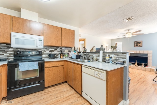 2666 Aarondavid Dr, Las Vegas, NV 89121 - kitchen featuring white appliances, a peninsula, decorative backsplash, light countertops, and light wood-type flooring