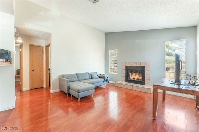 2666 Aarondavid Dr, Las Vegas, NV 89121 - living area with wood finished floors, a tile fireplace, and a textured ceiling