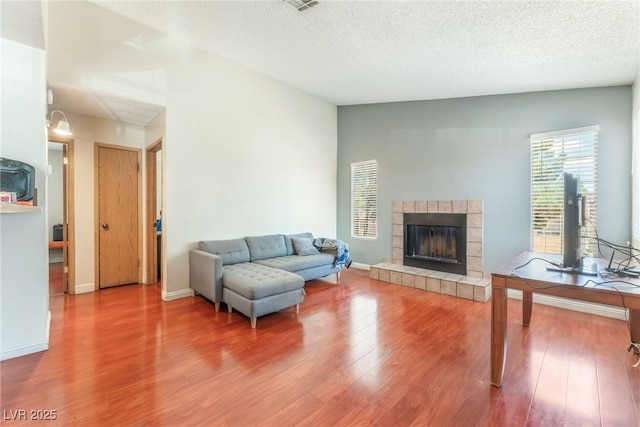 2666 Aarondavid Dr, Las Vegas, NV 89121 - living area with wood finished floors, a tile fireplace, and a textured ceiling