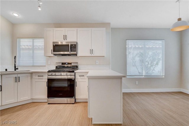 1005 Transom Dr, Las Vegas, NV 89128 - kitchen featuring stainless steel appliances, light wood-style flooring, light countertops, and white cabinetry