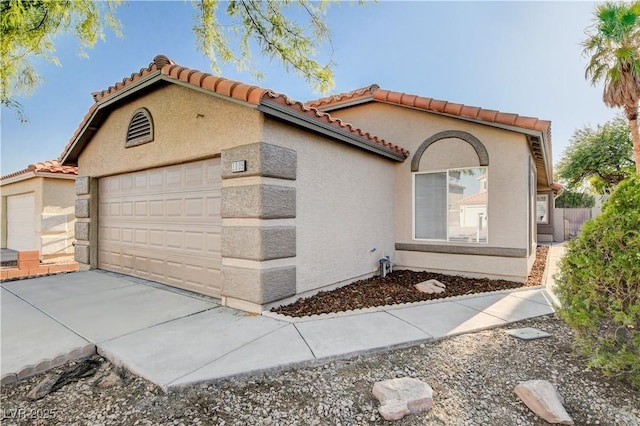 1005 Transom Dr, Las Vegas, NV 89128 - view of front of property featuring stucco siding, a garage, a tiled roof, and concrete driveway