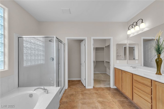 2244 Savannah River St, Henderson, NV 89044 - full bath featuring a shower stall, vanity, a spacious closet, a garden tub, and tile patterned floors
