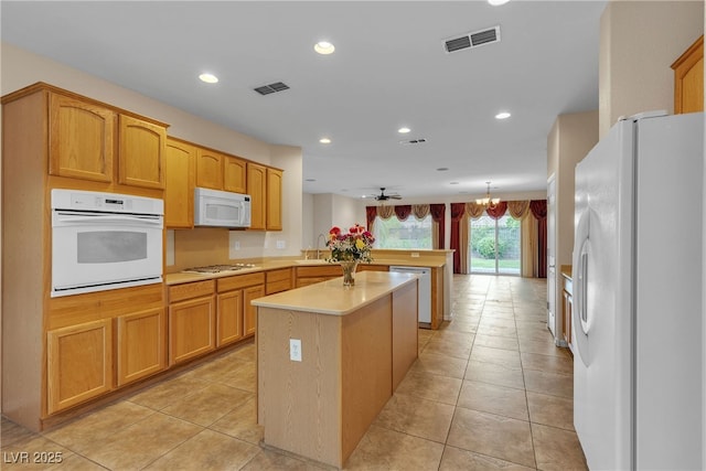 2244 Savannah River St, Henderson, NV 89044 - kitchen with white appliances, a peninsula, light countertops, a kitchen island, and recessed lighting