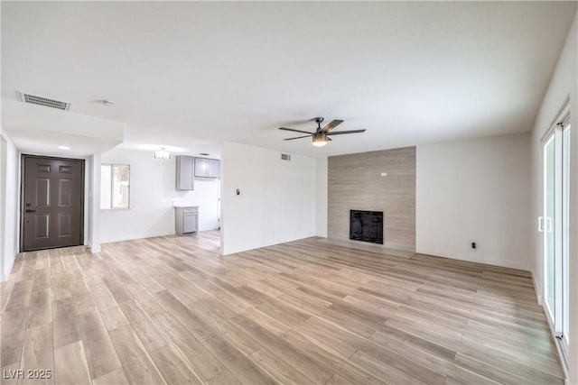 516 Donner St, Las Vegas, NV 89107 - unfurnished living room featuring ceiling fan, a large fireplace, and light wood-style floors