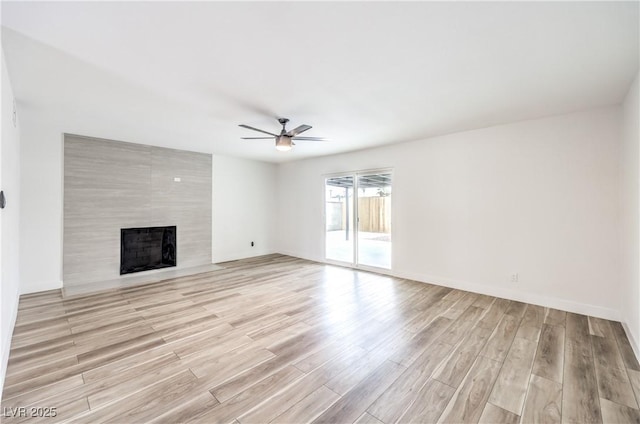 516 Donner St, Las Vegas, NV 89107 - unfurnished living room featuring a ceiling fan, light wood-style flooring, and a tile fireplace